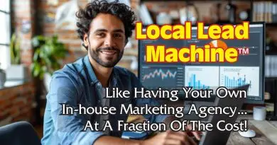 Young business man smiling and working on a laptop computer with monitors behind him displaying information