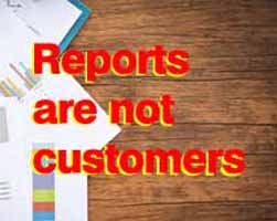 Reports and charts lying on a wooden table with the wprds reports are not customers